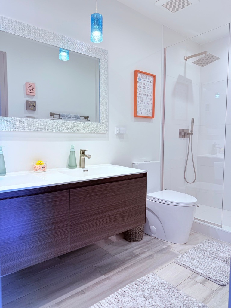 Finished bathroom with floating vanity and glass-enclosed shower